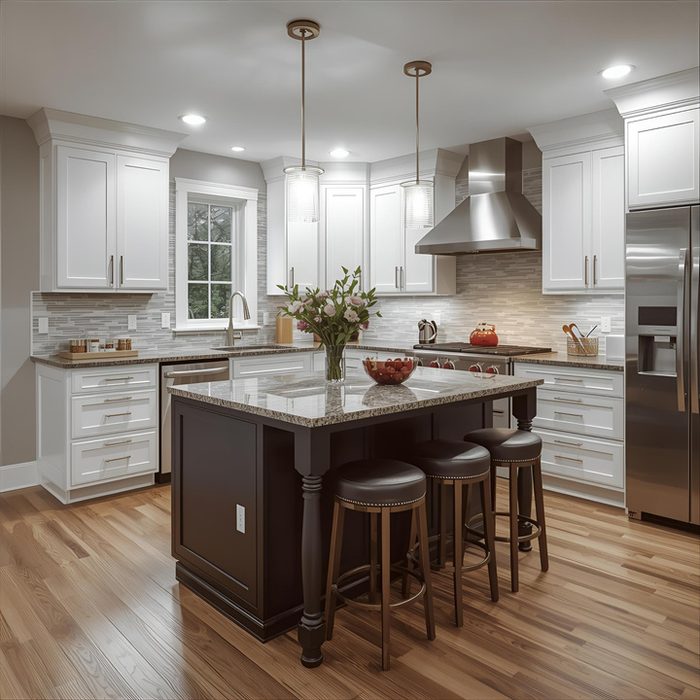 Remodeled kitchen with white cabinetry and dark island